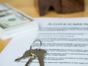 Image of a set of keys, stack of money, and purchase agreement, used for a blog for required forms for trailer purchases for Appalachian Trailers